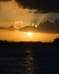 the sun is setting over a body of water