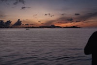 a person standing in the water at sunset